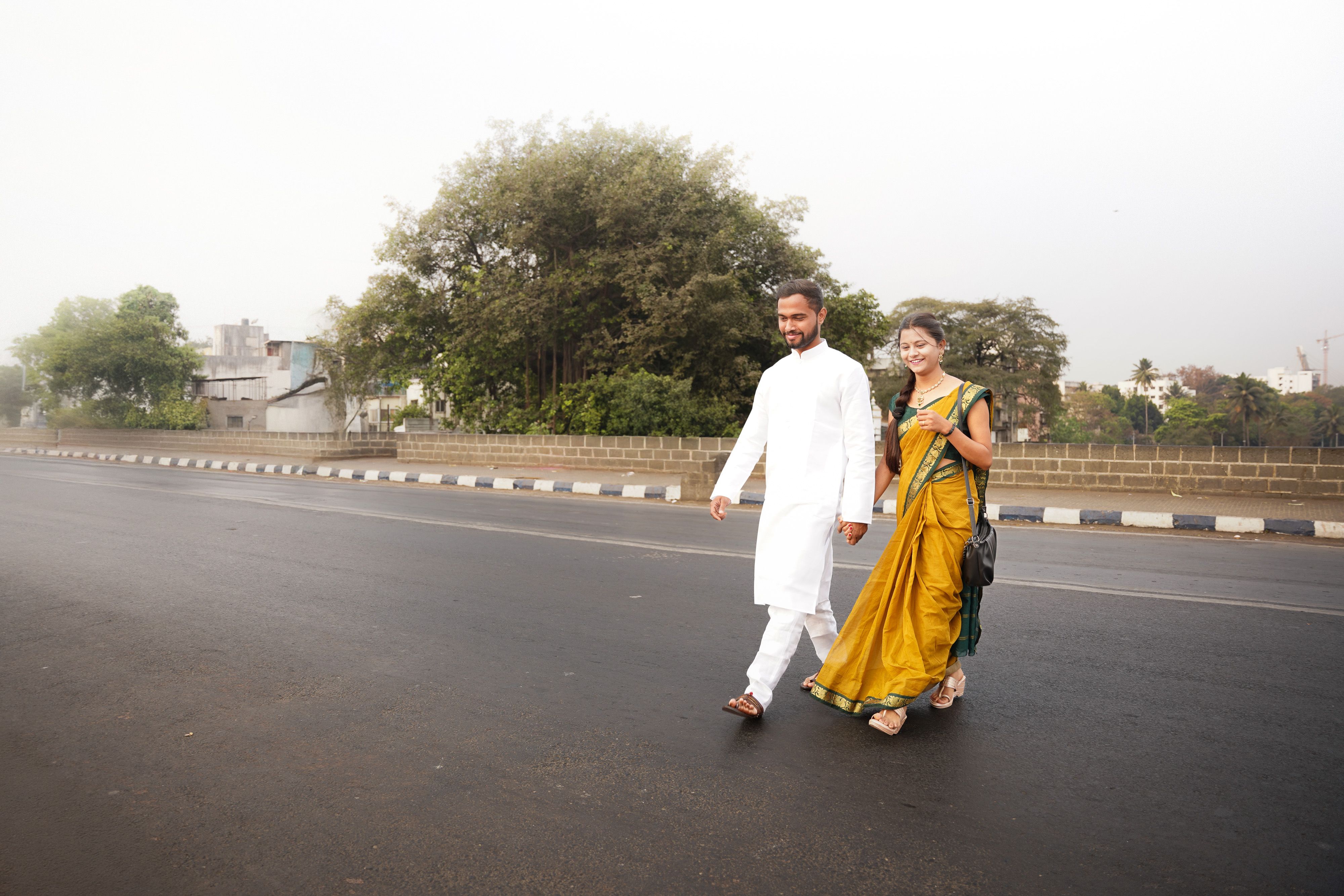 A smiling couple in traditional clothes walking outdoors