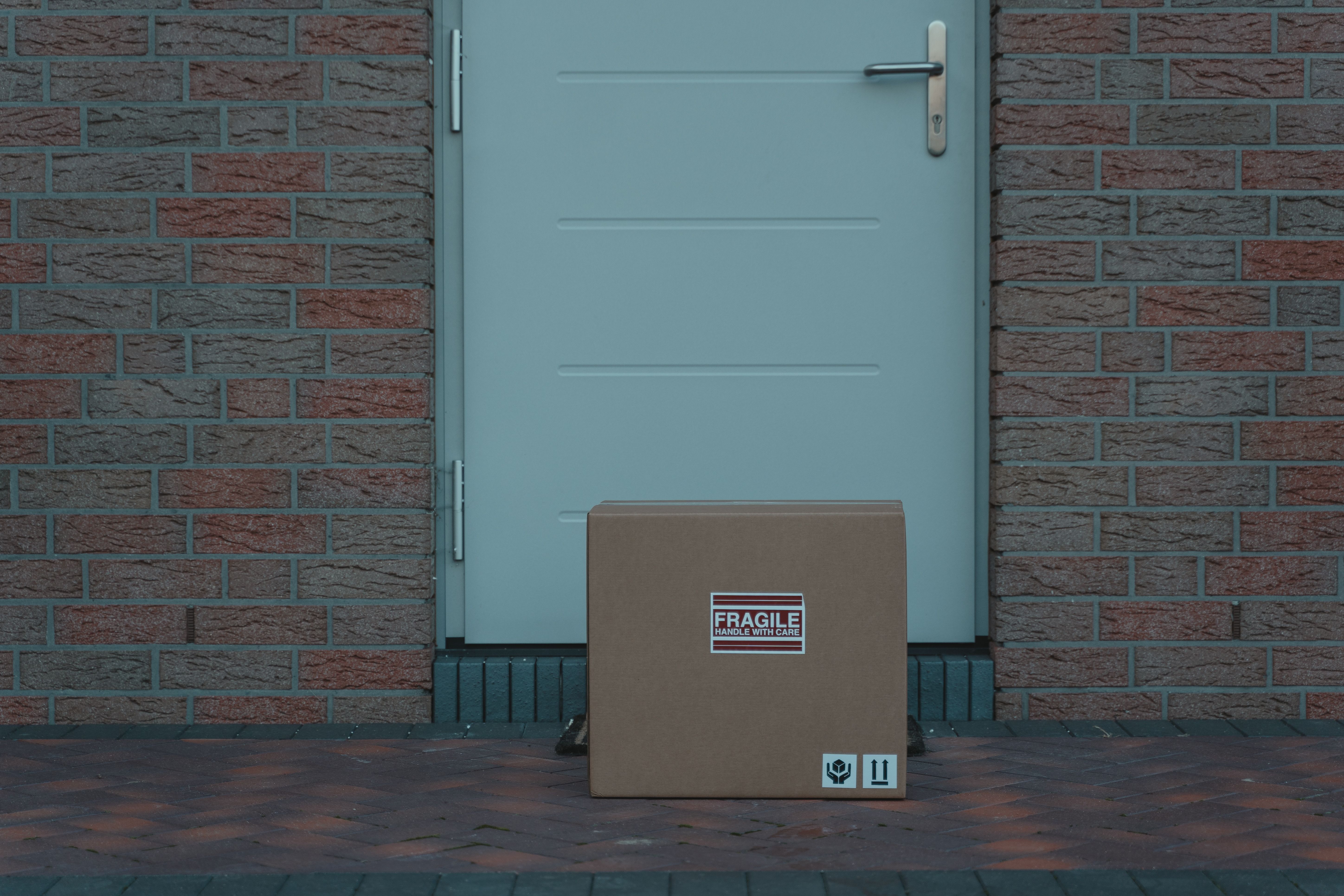 A cardboard parcel in front of an entrance door